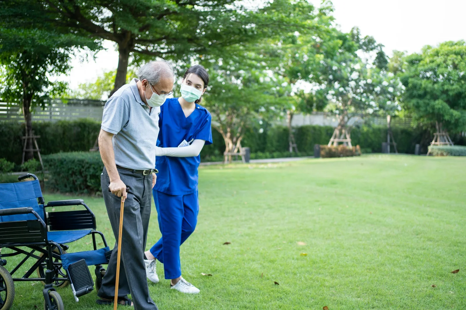 asian-young-woman-nurse-support-disabled-senior-elderly-man-on-wheelchair-at-backyard-
