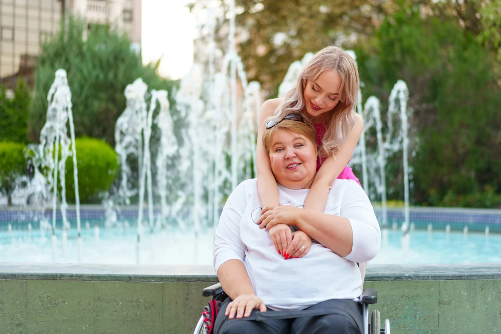 young-daughter-taking-care-of-her-mother-with-disability-sitting-in-wheelchair