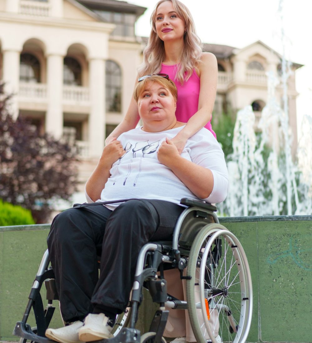 Young daughter taking care of her mother with disability sitting in wheelchair